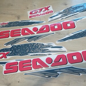 K&ouml;nnte beinhalten: Ein Satz roter und grauer Vinyl-Aufkleber mit dem Text "Sea-Doo" und "GTX" f&uuml;r ein Sea-Doo-Wasserfahrzeug.