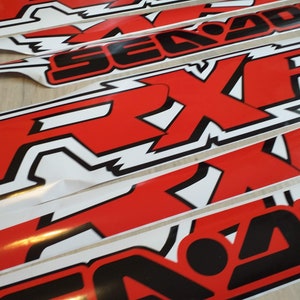 May include: Multiple red and black Sea-Doo stickers with the word "Sea-Doo" and the logo "RXP" in white.