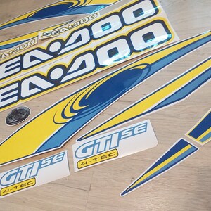 May include: A set of yellow and blue Sea-Doo decals with the text "Sea-Doo" and "Sea 400" and "GTi SE 4-TEC".