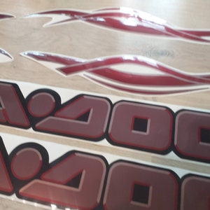 May include: Two red and white decals with the text "Sea-Doo" in a 3D-style font. The decals are on a white background.