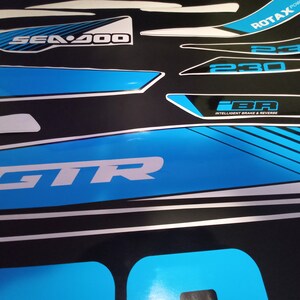 May include: A set of blue and white decals for a Sea-Doo GTR watercraft. The decals feature the Sea-Doo logo, the model name GTR, and the engine size 230. The decals also include the text "iBR" for Intelligent Brake & Reverse and "ROTAX Power".
