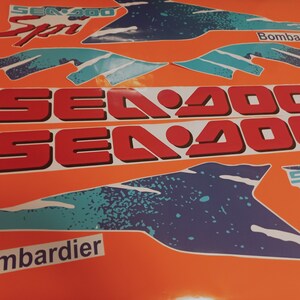 K&ouml;nnte beinhalten: Ein Satz Sea-Doo-Aufkleber in Rot, Wei&szlig; und Blau. Die Aufkleber zeigen das Sea-Doo-Logo und den Text "Sea-Doo" und "Bombardier".