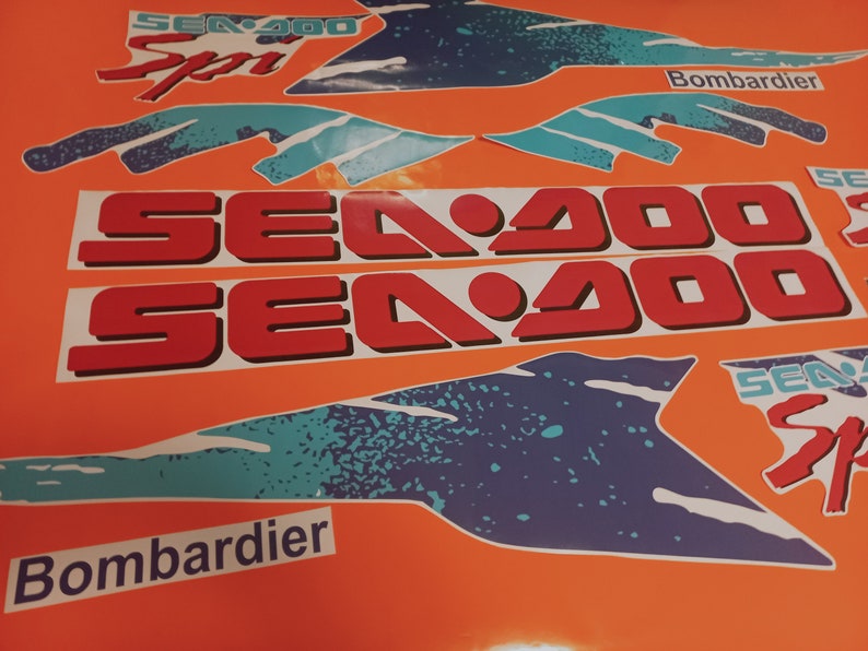 K&ouml;nnte beinhalten: Ein Satz Sea-Doo-Aufkleber in Rot, Wei&szlig; und Blau. Die Aufkleber zeigen das Sea-Doo-Logo und den Text "Sea-Doo" und "Bombardier".