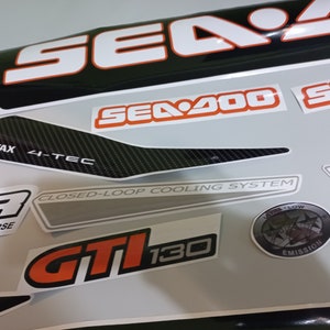 May include: A set of black and white Sea-Doo decals with orange accents. The decals include the words "Sea-Doo", "Sea-Doo 4-Tec", "GT1130", "Closed-Loop Cooling System", "Ultra Low Emission", and "Rotax 4-Tec".