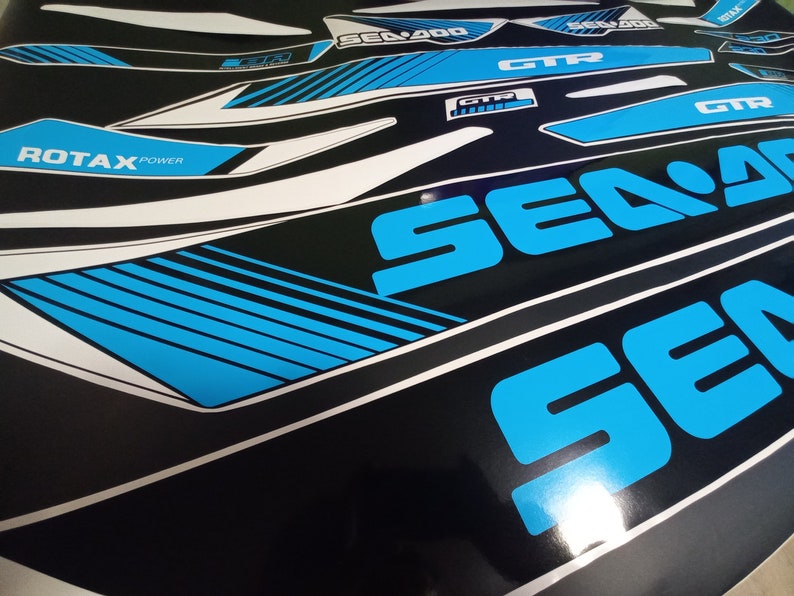 May include: A set of blue and white decals for a Sea-Doo watercraft. The decals feature the Sea-Doo logo, the words "Sea-Doo", "GTX", and "ROTAX POWER".