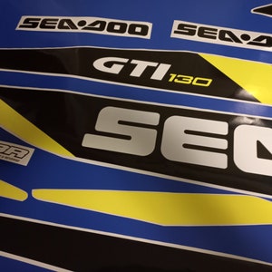 May include: A black and white Sea-Doo GTI 130 sticker set with yellow accents. The stickers feature the Sea-Doo logo and the model name.