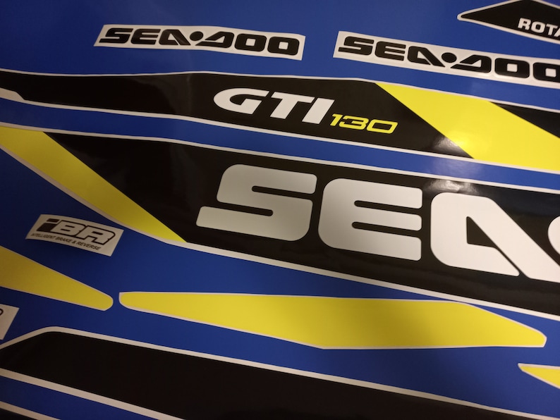May include: A black and white Sea-Doo GTI 130 sticker set with yellow accents. The stickers feature the Sea-Doo logo and the model name.