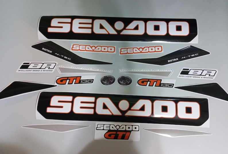 May include: A set of black and white Sea-Doo decals with orange accents. The decals feature the Sea-Doo logo, the model name "Sea-Doo 400", and the text "GTI 130".