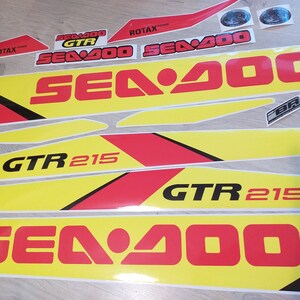 May include: A set of yellow and red decals with the text "Sea-Doo" and "GTR 215".
