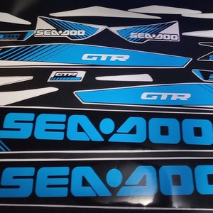 May include: A set of blue and white Sea-Doo GTR watercraft decals. The decals feature the Sea-Doo logo, the model name "GTR", and the engine size "900". The decals are designed for use on a Sea-Doo watercraft.
