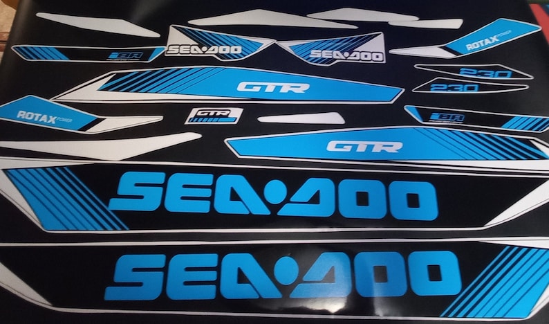 May include: A set of blue and white Sea-Doo GTR watercraft decals. The decals feature the Sea-Doo logo, the model name "GTR", and the engine size "900". The decals are designed for use on a Sea-Doo watercraft.