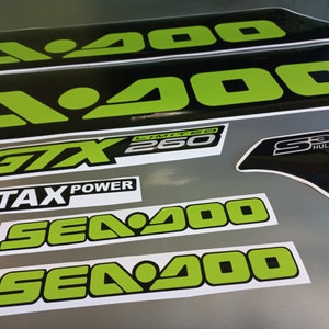 May include: A set of black and green Sea-Doo decals with the text "Sea-Doo", "GTX 260 Limited", "Sea-Doo", "Sea-Doo", "S3 Hull", and "Rotax Power".