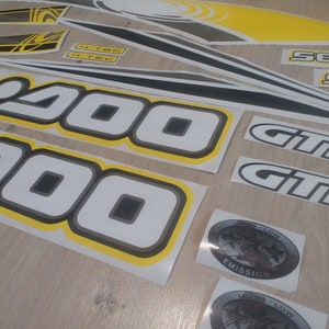 May include: A set of black and white decals with yellow trim. The decals feature the text "Sea-Doo", "GTIS", and "200".