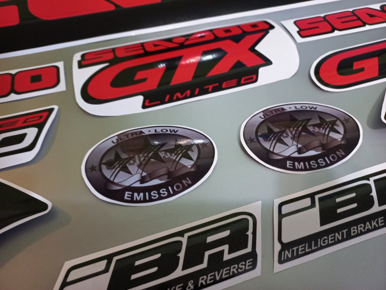 May include: A set of black and red decals with the text "Sea-Doo GTX Limited" and "Ultra Low Emission" in white. The decals are designed for a motorcycle or watercraft.