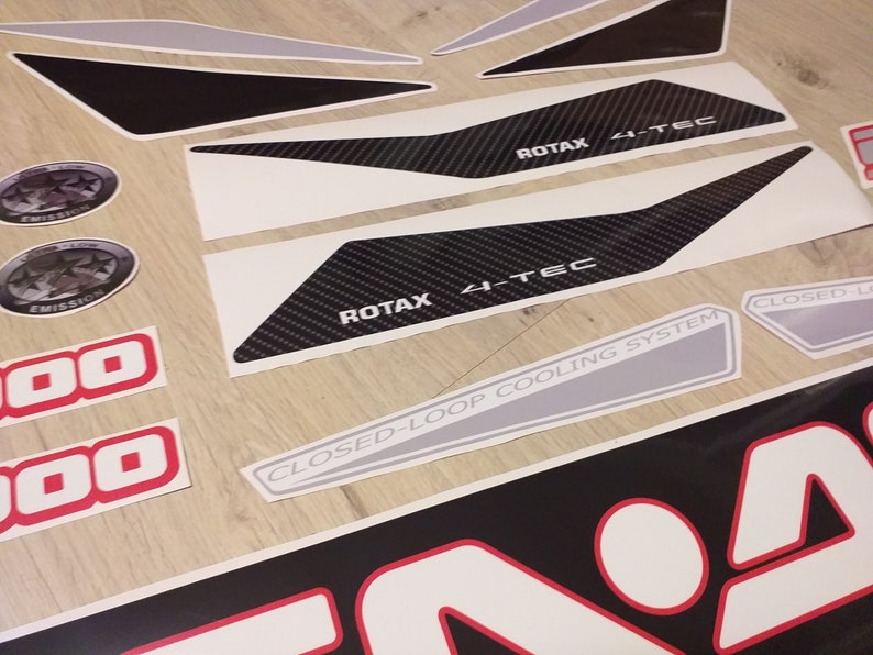 May include: A set of black and white decals with a carbon fiber pattern and the text "ROTAX 4-TEC" and "CLOSED-LOOP COOLING SYSTEM".