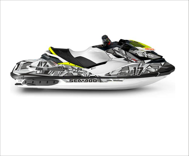 May include: A white Sea-Doo Spark 900 jet ski with a black and gray camouflage design. The jet ski has a yellow and black Riva Racing logo and the number 117 on the side.