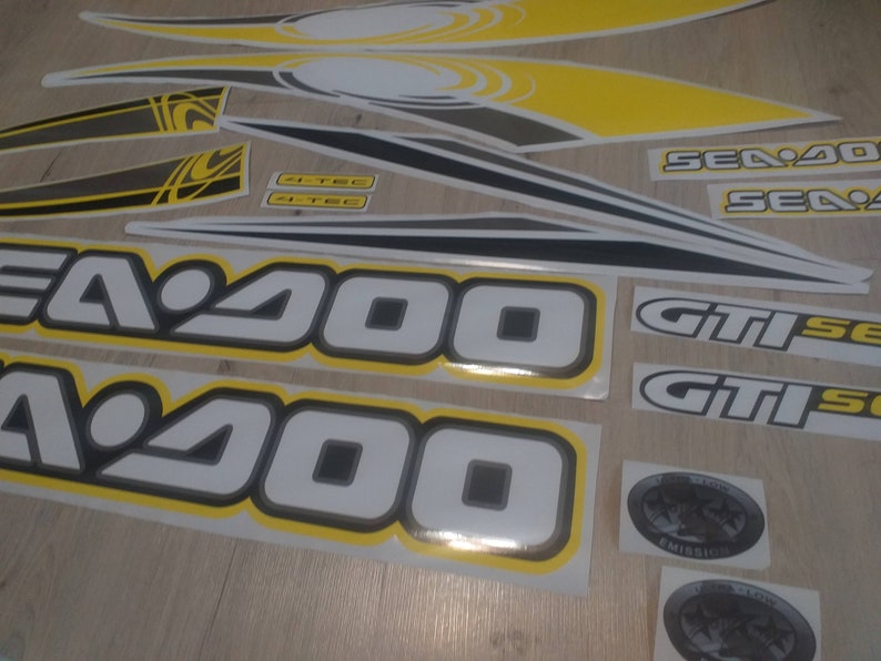 May include: A set of black, white, and yellow Sea-Doo GTI decals. The decals feature the text "Sea-Doo", "GTI", and "Sea-Doo GTI".
