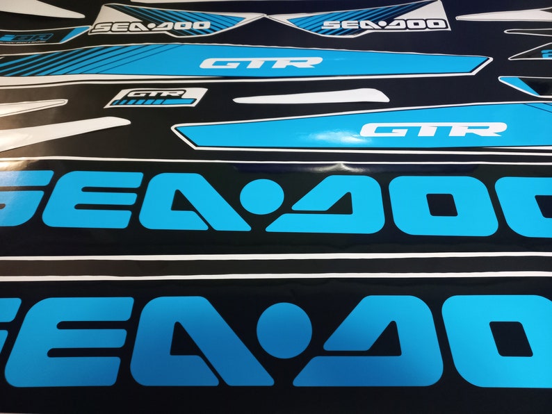 May include: Close-up of two blue and black Sea-Doo decals with the text "Sea-Doo" and "Sea-Doo 200" in white.