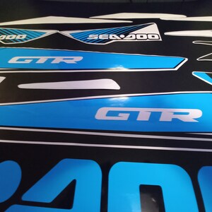 May include: A set of blue and white Sea-Doo GTR decals with the text "Sea-Doo" and "GTR".