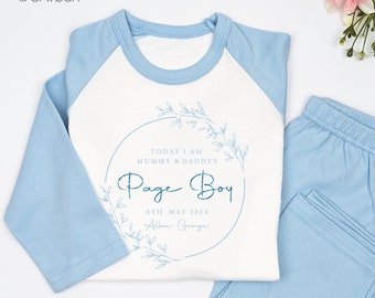 May include: A light blue and white pajama set. The top has light blue sleeves and a white body with the text "Today I am Mummy & Daddy's Page Boy" inside a floral wreath. The matching pants are light blue.
