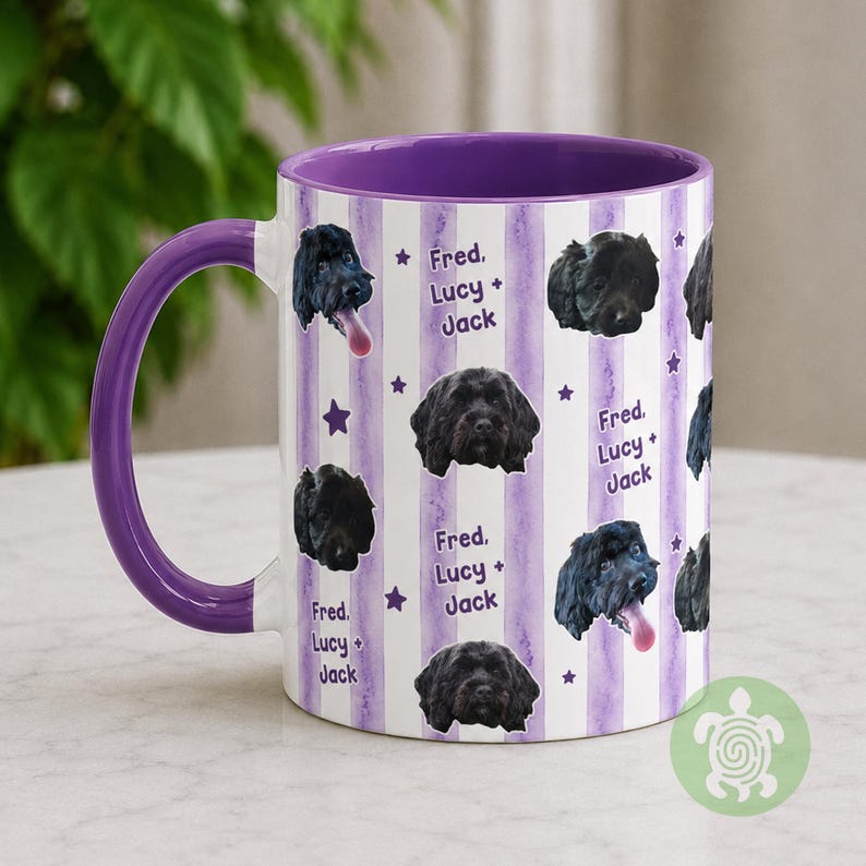 May include: A ceramic mug with a purple handle and interior, featuring a white background with vertical light purple watercolor stripes. The design includes repeating portraits of a black dog and the printed text Fred, Lucy + Jack with stars.