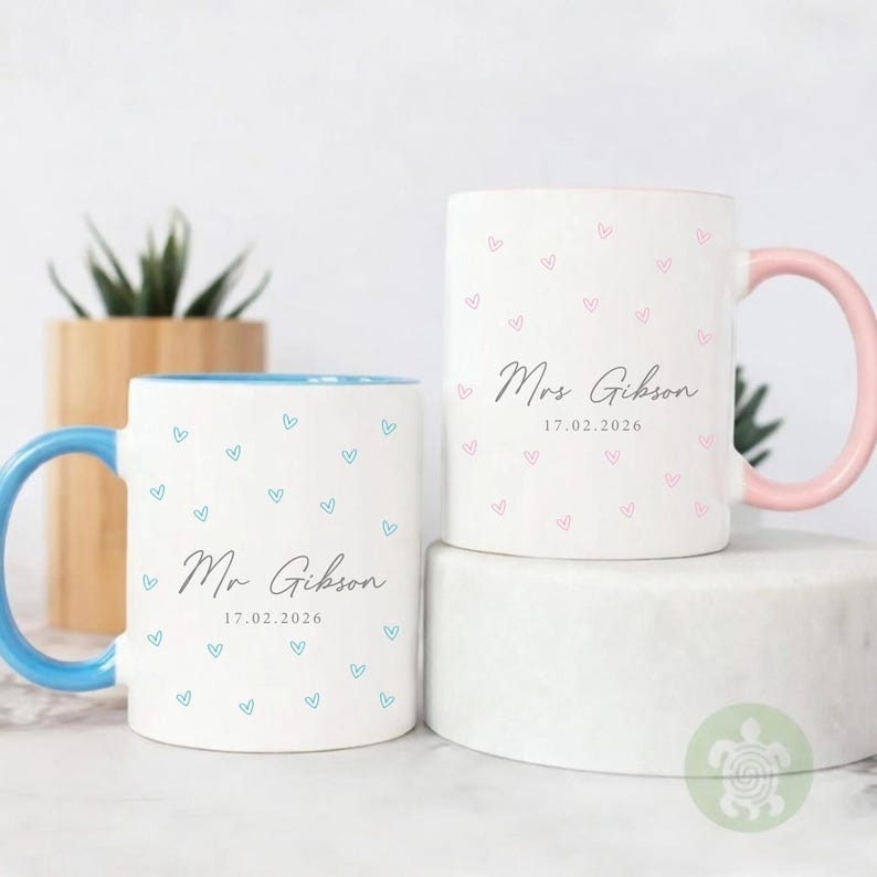 May include: A white ceramic mug with a black handle and the text "But First, Coffee" in a bold, black font. The mug is set against a neutral background, highlighting its simple design.