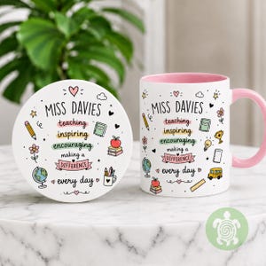 May include: A white ceramic mug and matching round coaster featuring a pink interior and handle. The design includes the text "MISS DAVIES" and "teaching inspiring encouraging making a difference every day" surrounded by colorful school-themed icons.