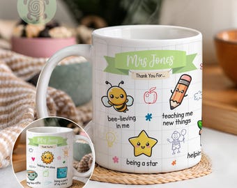 May include: White ceramic mug with a handle, featuring a green banner with "Mrs Jones" and "Thank You For..." printed on it. The mug is decorated with colorful illustrations of a bee, apple, pencil, star, and other graphics. The mug is sitting on a woven coaster.