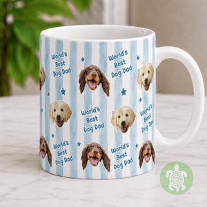 May include: A white ceramic mug featuring a repeating pattern of light blue vertical watercolor stripes, small blue stars, and the text World's Best Dog Dad. The design includes photographic portraits of two different dog breeds with open mouths.