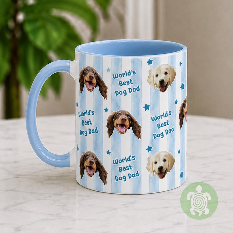 May include: A ceramic mug with a light blue handle and interior, featuring a repeating pattern of light blue vertical stripes, small blue stars, and the text World's Best Dog Dad alongside photographic portraits of brown and cream-colored dogs.