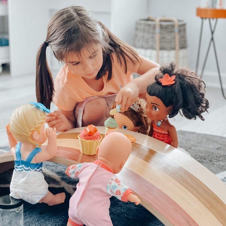 Child using a wobble board as part of an indoor obstacle course, promoting balance, coordination, and creative kid pretend play.