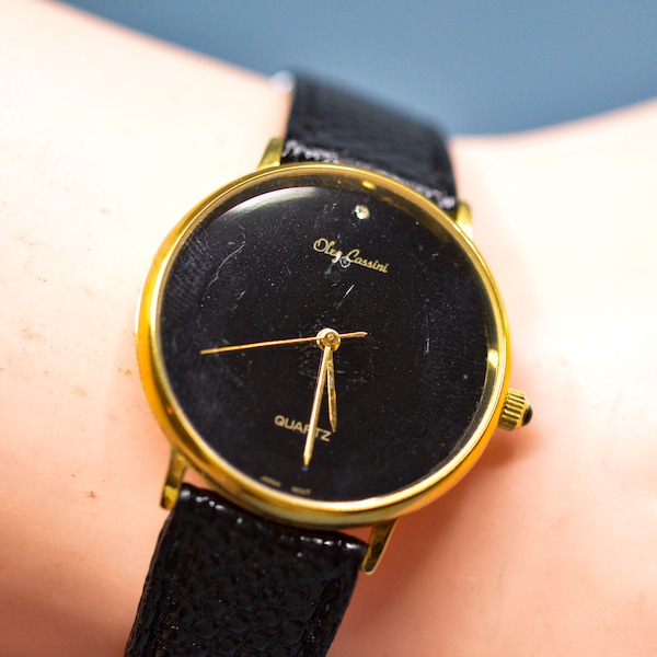 Oleg Cassini , gold tone with black dial, quartz wrist watch