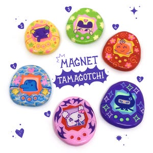 Peut inclure: Six porte-clés aimantés Tamagotchi colorés avec différents personnages et designs. Les porte-clés sont ronds et présentent une variété de couleurs, notamment le rose, le bleu, le vert, le jaune, le rouge et le violet. Les porte-clés sont décorés d'étoiles, de cœurs et d'autres motifs amusants.