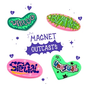 Peut inclure: Quatre aimants en forme de cœur et d'ovale avec des mots différents écrits dessus. Les mots sont "Weirdo", "Bizarre", "Unusual", et "Special". Les aimants sont verts, roses et bleus avec des accents blancs et noirs. Les mots sont écrits dans une police colorée et ludique. Les aimants sont disposés en forme de carré avec les mots "Magnet Outcasts" écrits au centre.