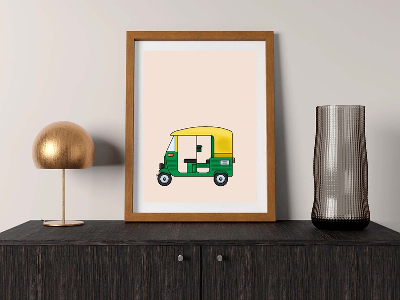 May include: A framed illustration of a green and yellow auto rickshaw, also known as a tuk-tuk, on a light peach background.