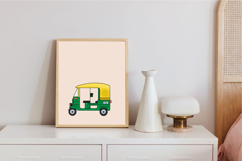 May include: A framed illustration of a green and yellow auto rickshaw, also known as a tuk-tuk, on a light peach background.