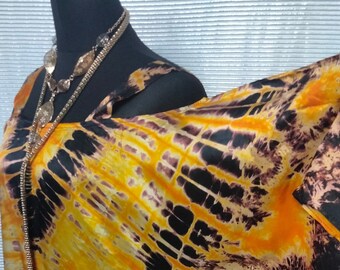 Può includere: Un lungo abito fluido con stampa tie-dye arancione e nero con scollo halter. L'abito è realizzato in tessuto setoso e ha una vestibilità rilassata.