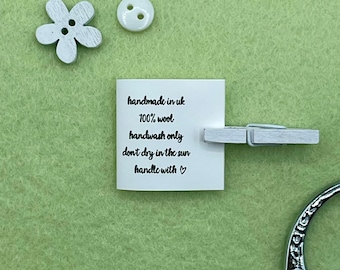 May include: White card with black text that reads "handmade in uk 100% wool handwash only don't dry in the sun handle with ♥".