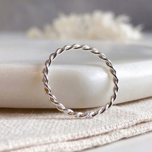 May include: A silver twisted band ring. The ring is simple and delicate.