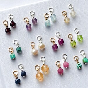 May include: A collection of 10 pairs of gemstone charms, each pair featuring a different color and type of gemstone. The charms are made of silver and gold and are perfect for adding a touch of sparkle to jewelry.
