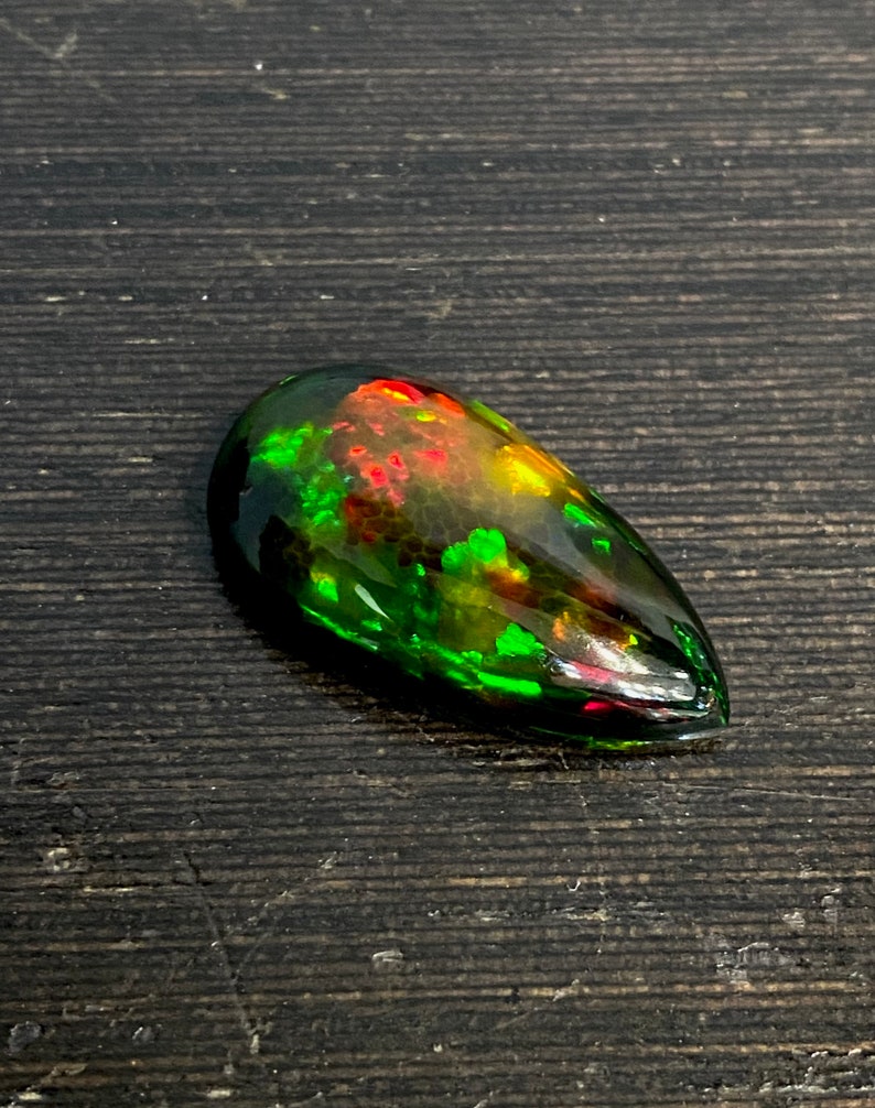 Eld! 21,85 CTS Svart honeycomb-opal från Etiopien. Gulgrön dominerad sten, ren färgnyans med massor av eld. bild 1