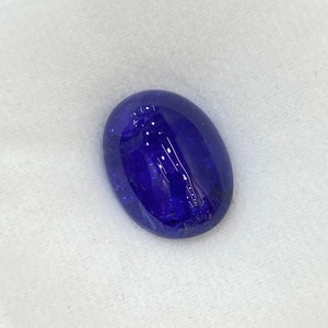 May include: A deep blue oval-shaped gemstone with a smooth, polished surface.