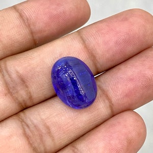 May include: A deep blue oval-shaped gemstone with a smooth, polished surface.