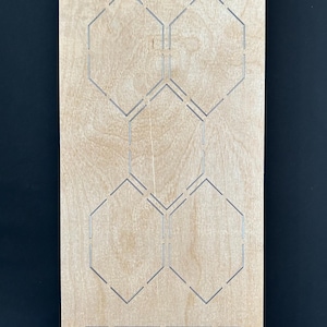 May include: A wooden die-cut template with a series of interconnected hexagonal shapes and rectangular cutouts. The text "EP-HC-ST-1 1/2" is printed at the top. The template is made of light-colored wood.