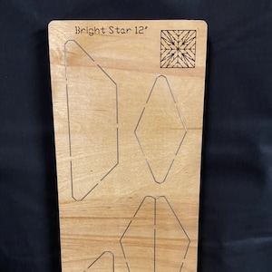 May include: A wooden craft template with the text "Bright Star 12" and several geometric cutouts. The template is rectangular and made of light-coloured wood. The cutouts include diamond, trapezoid, and other angular shapes.