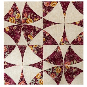 May include: A square patchwork quilt block with a repeating pattern of curved shapes. The design uses burgundy floral fabric with yellow and pink flowers, and cream-coloured fabric. The block is likely part of a larger quilt.