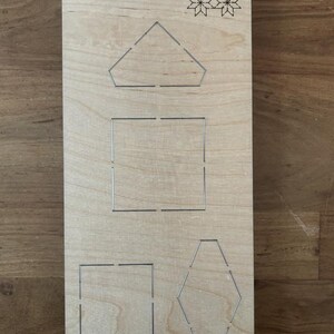 Könnte beinhalten: Eine Holzstanzschablone mit dem Text "Fabric Scarlet EP-8P-SC-FB-1½" und geometrischen Formen. Die Formen umfassen ein Fünfeck, ein Quadrat und ein Sechseck. Ein dekoratives Blumenmuster ist ebenfalls vorhanden.