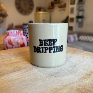 Könnte beinhalten: Ein beigefarbener Keramikbehälter mit dem Text "BEEF DRIPPING" in schwarzen Buchstaben.