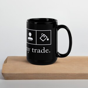 Op de afbeelding: Zwarte keramische mok met witte pictogrammen en de tekst "My trade." De pictogrammen tonen een persoon en een emmer verf.