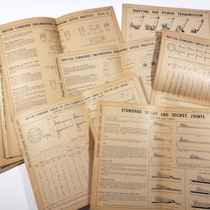 May include: A stack of vintage engineering drawing office practice manuals with titles such as "British Standard Tables of Pipe Flanges" and "Standard Spigot and Socket Joints".